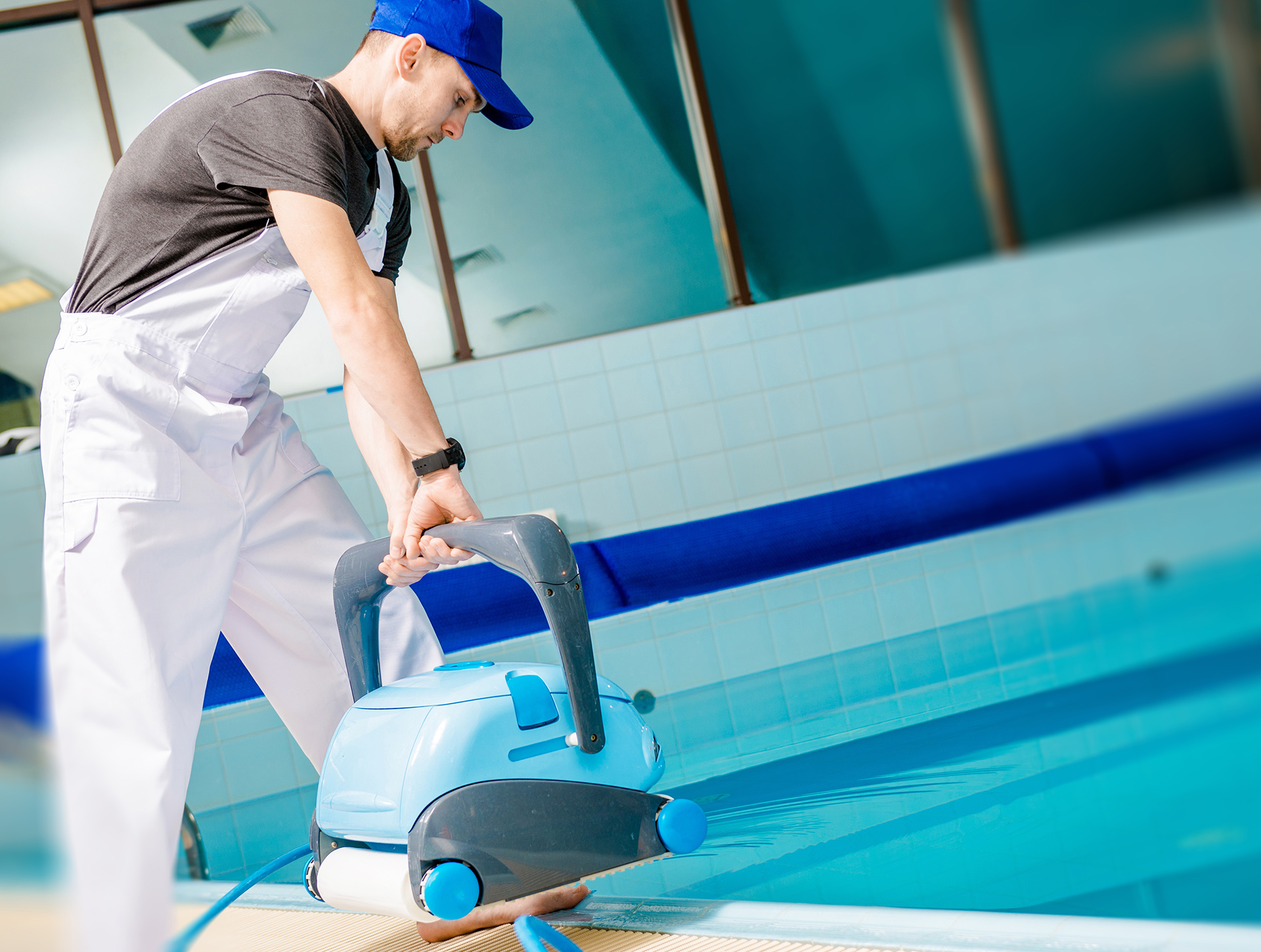 Swimming Pool Technician with Automated Pool Cleaner Preparing For Cleaning.